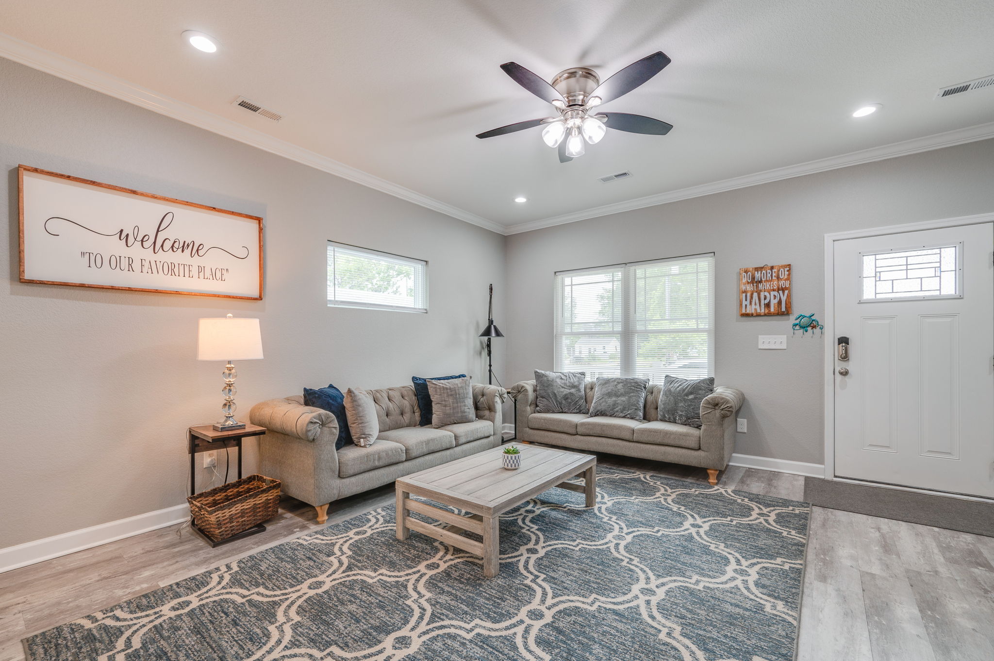 Bright and spacious living area with comfortable sofas and modern ceiling fan.