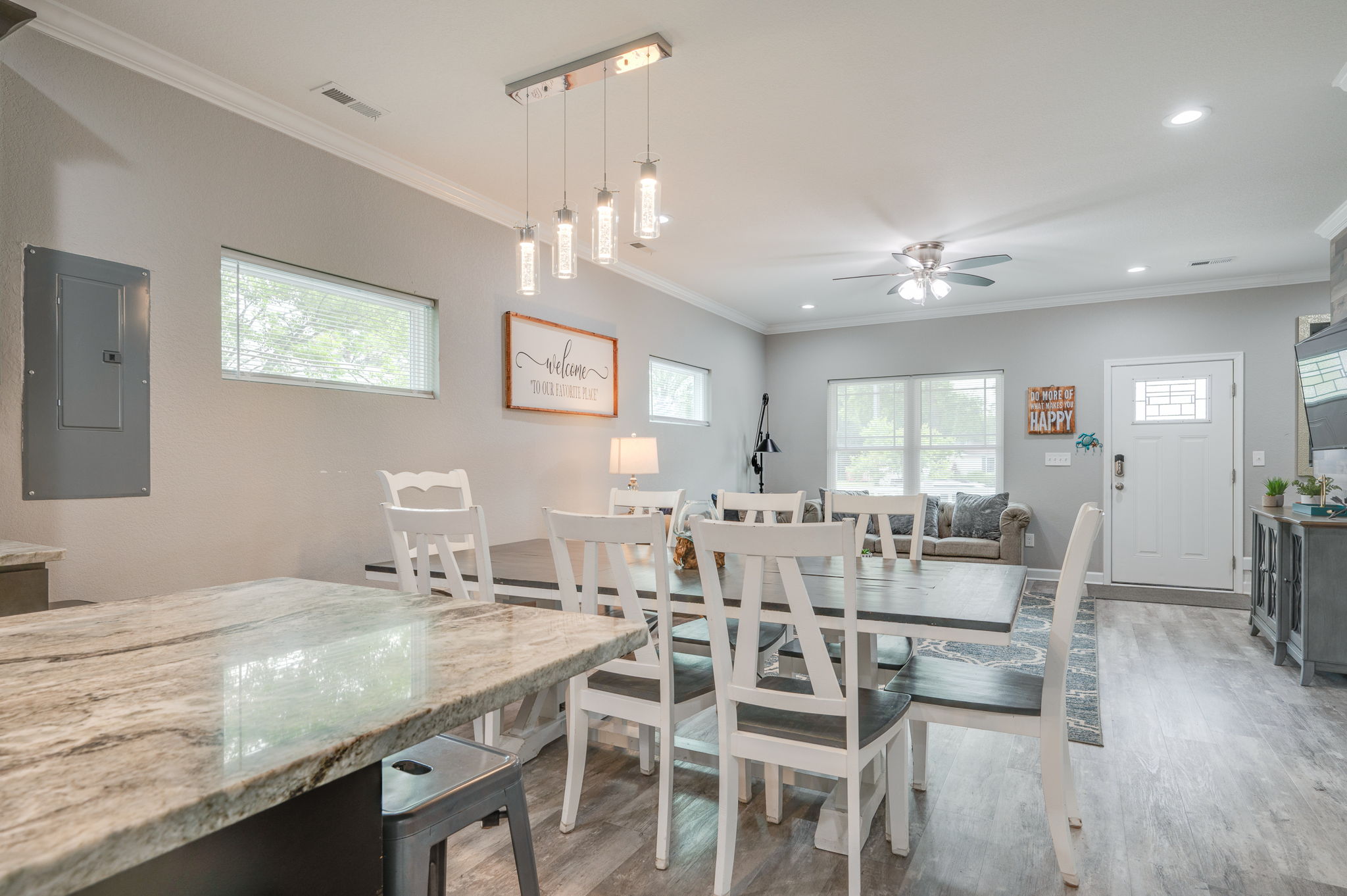 Dining and living area with contemporary lighting and open layout.