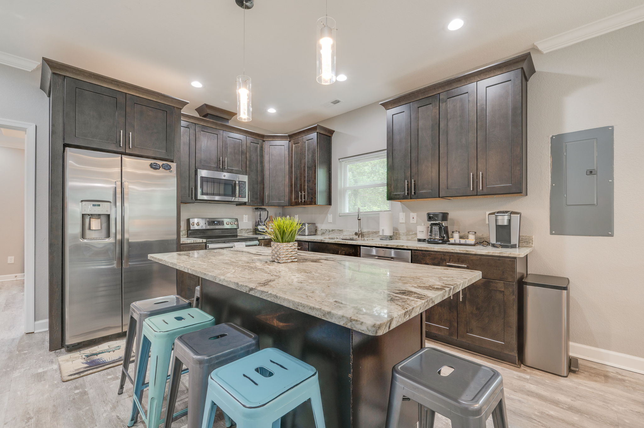 Modern kitchen with dark cabinetry, stainless steel appliances, and granite countertops.