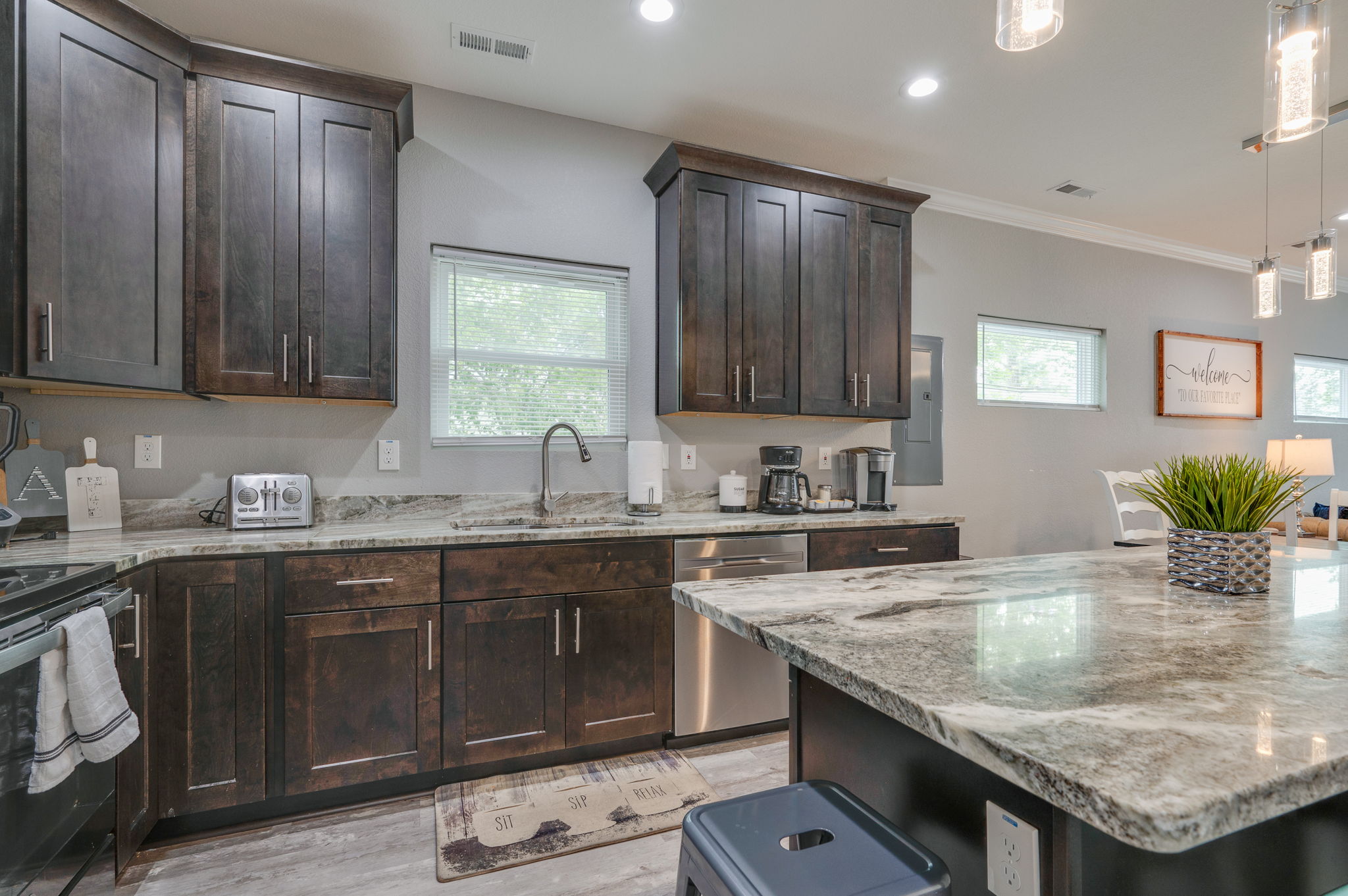 Close-up of kitchen island with bar seating and stylish pendant lighting.