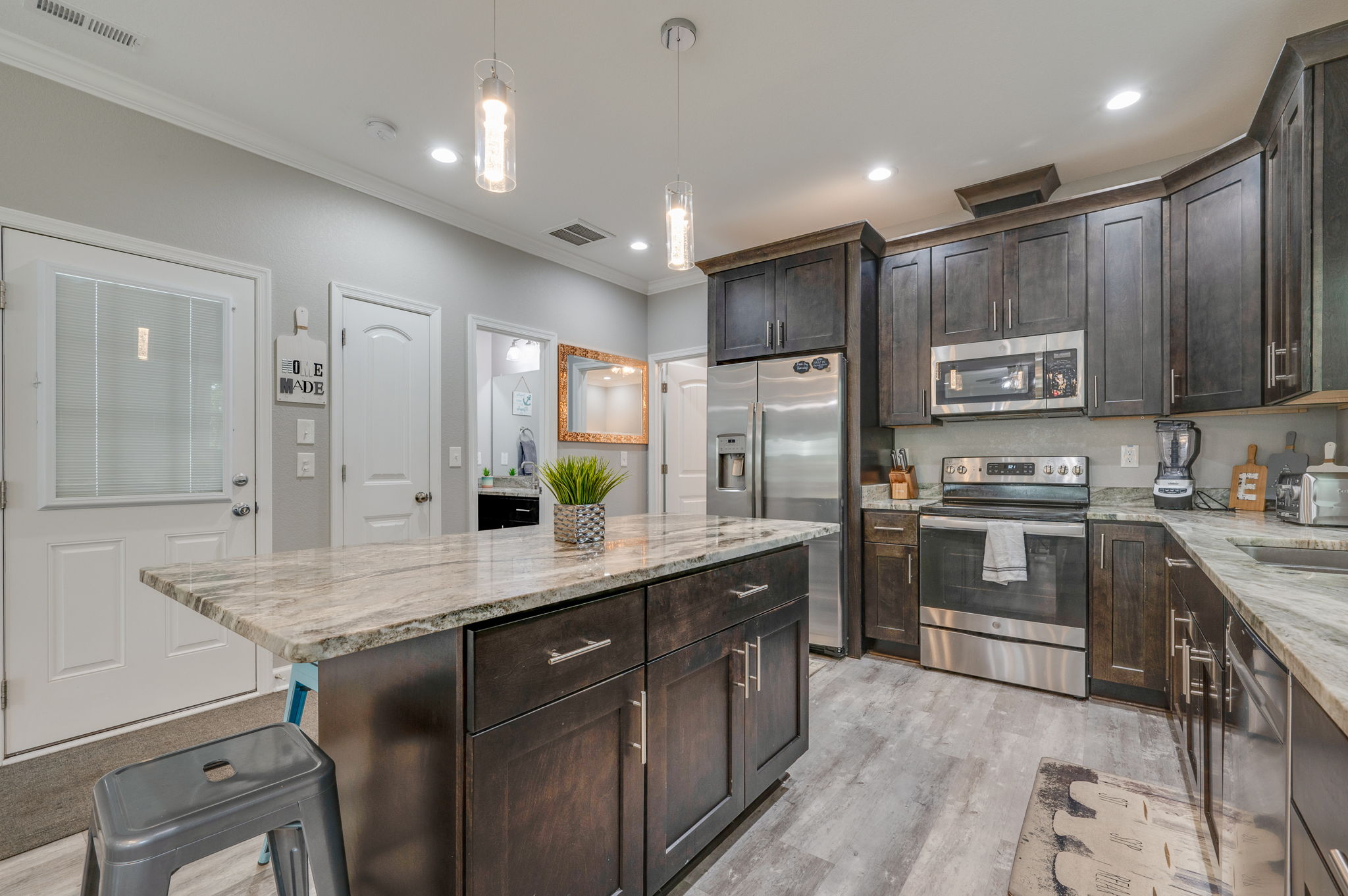 Bathroom with granite countertop, large mirror, and elegant decor.