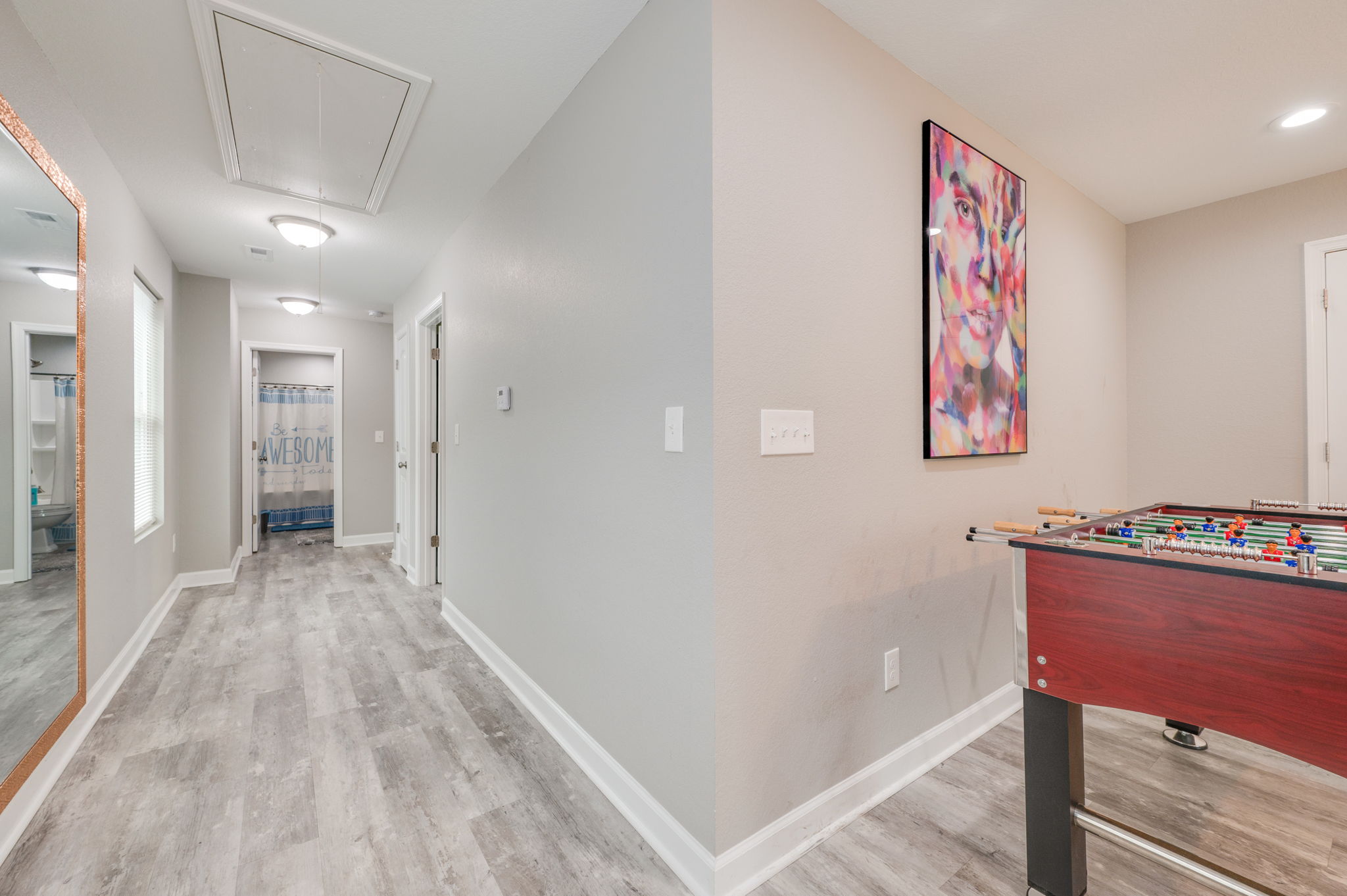 Second-floor entertainment room with wall-mounted TV and cozy seating.