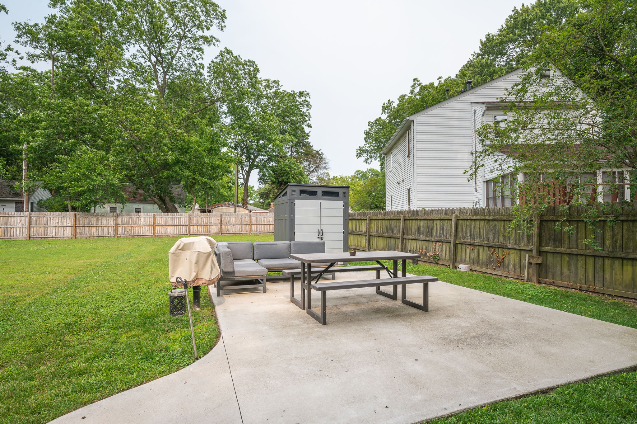 Spacious backyard with lush green lawn and outdoor amenities.