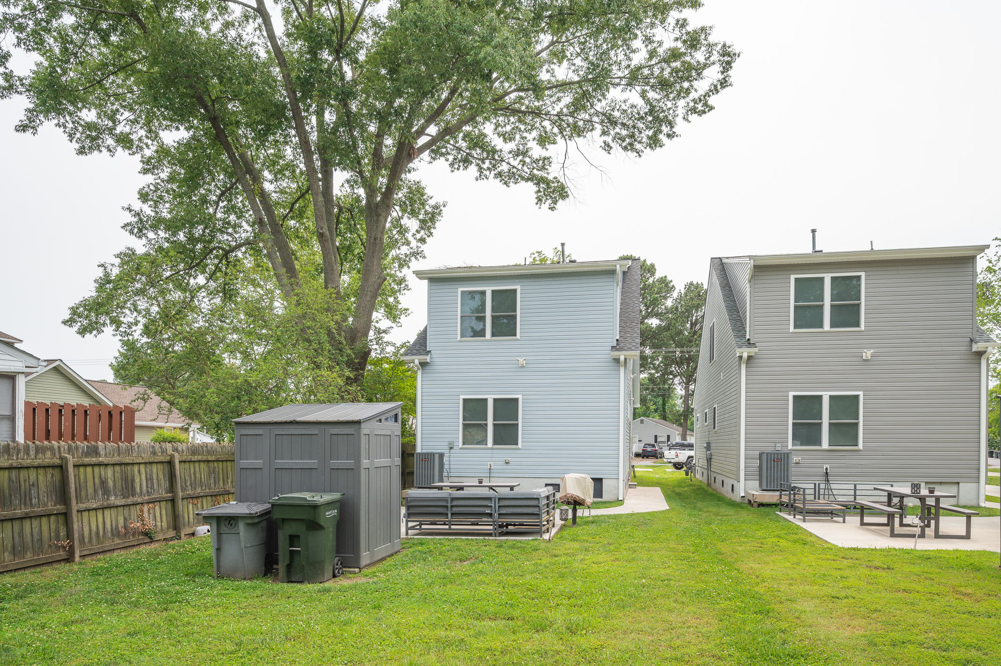 Backyard view showing seating area and fenced yard.