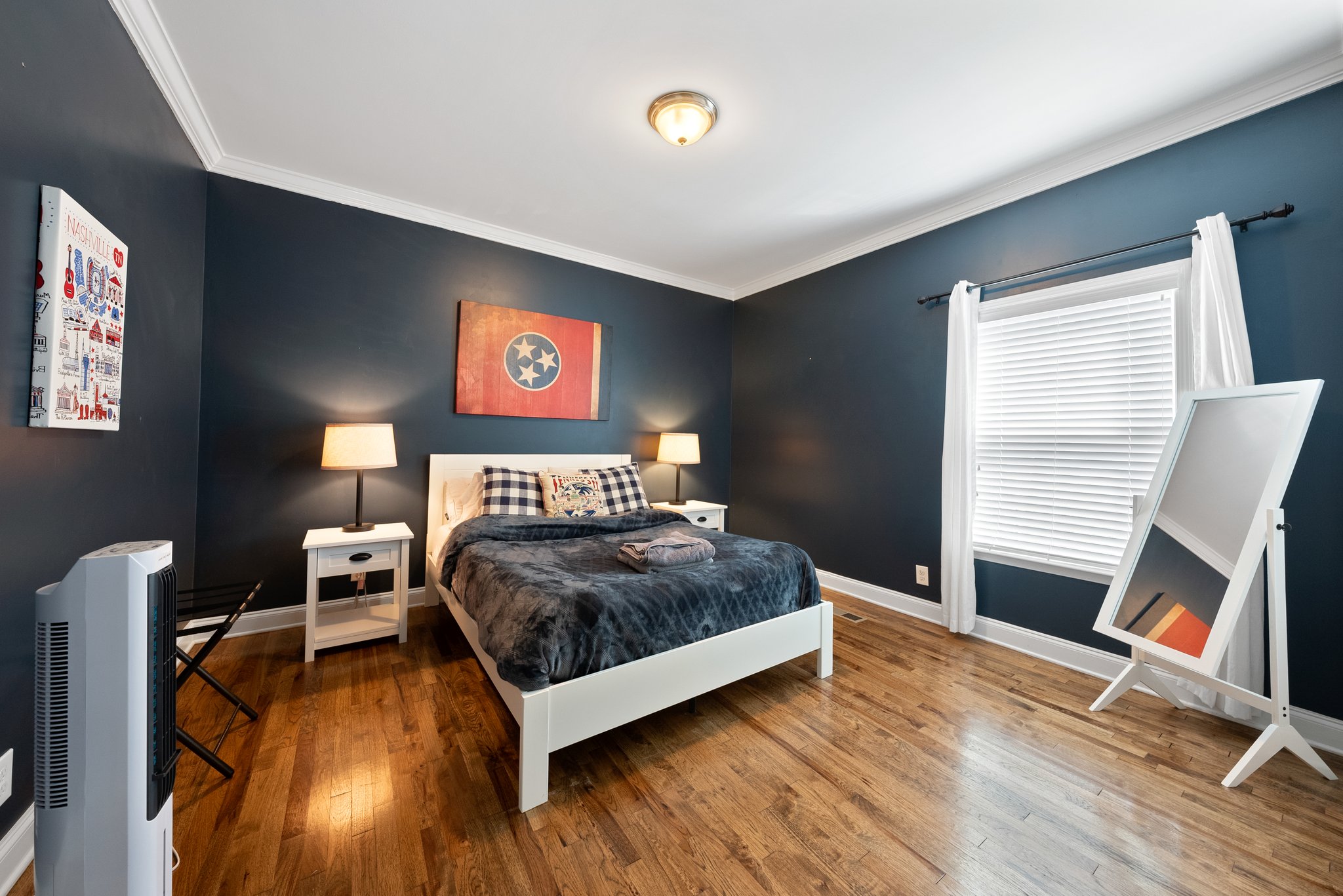 Bedroom with dark accent walls, white furniture, and Tennessee-themed d?cor