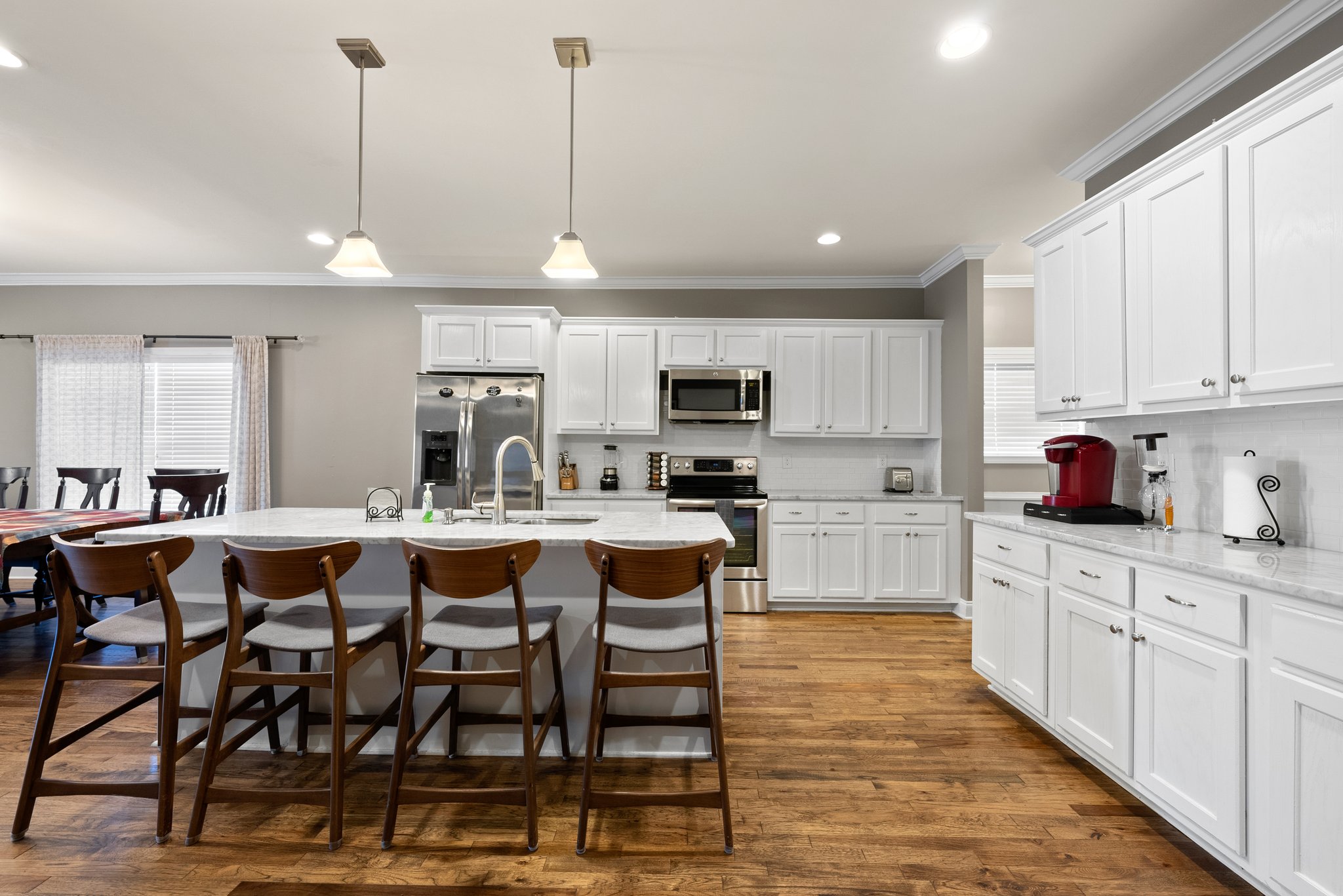 Spacious kitchen featuring large island, stainless steel appliances, and dining area