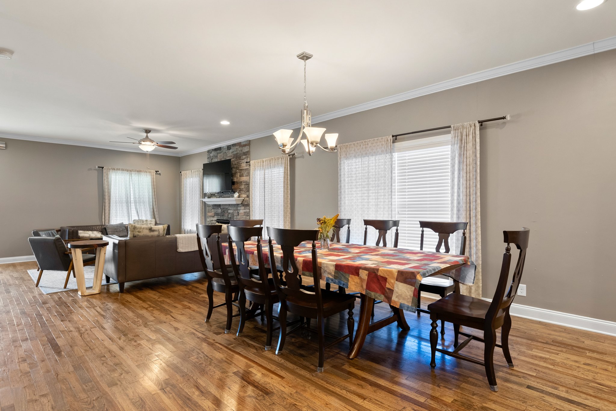 Dining room with large wooden table, chandelier, and seating for ten