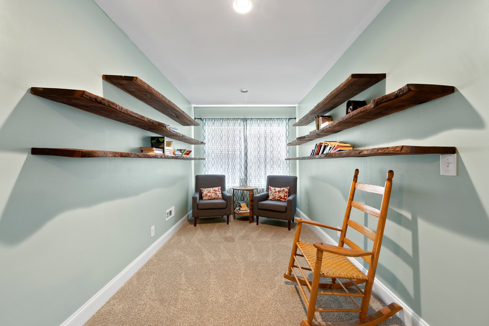 Reading nook with light green walls and floating shelves