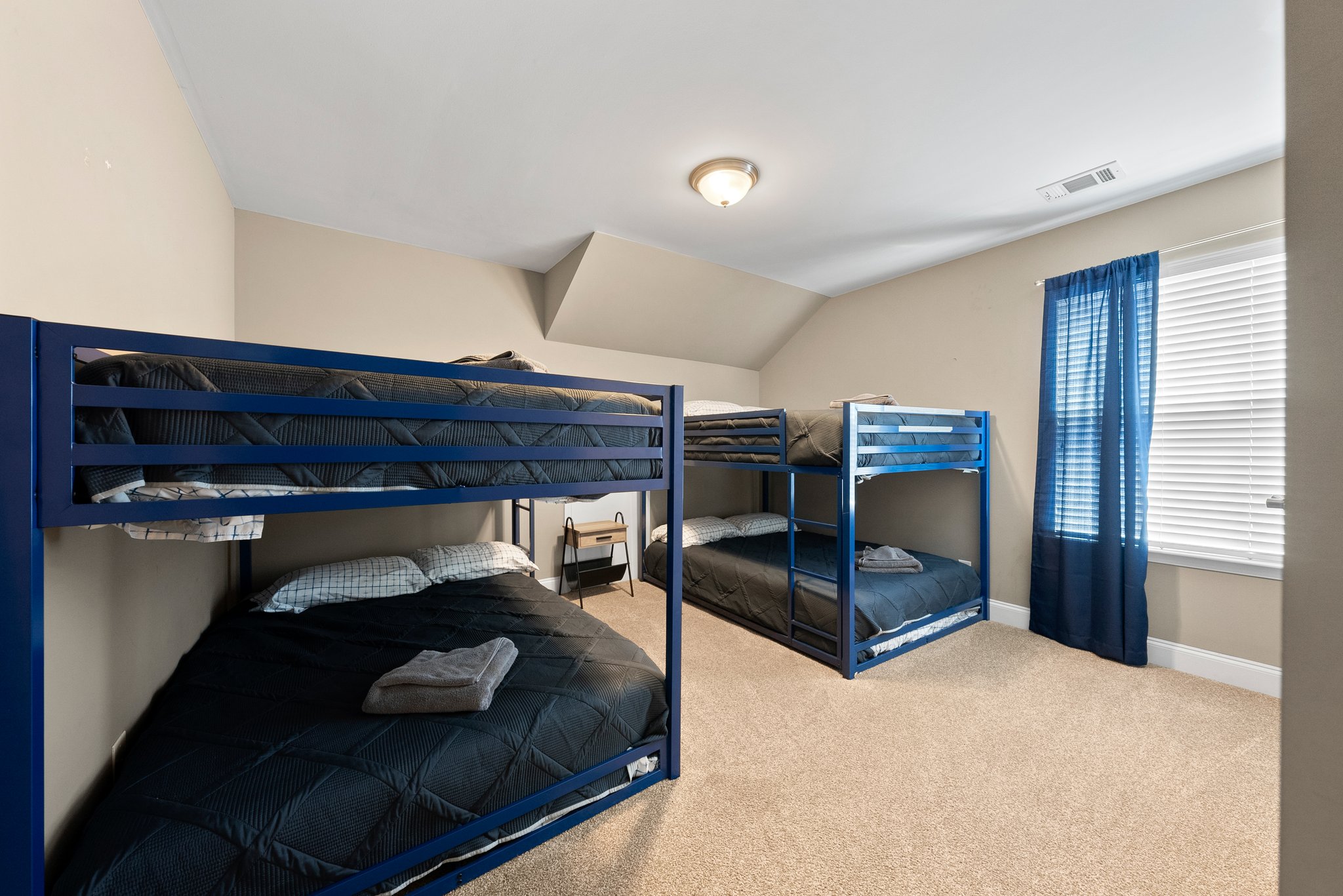 Bunk room with blue bunk beds and beige carpet
