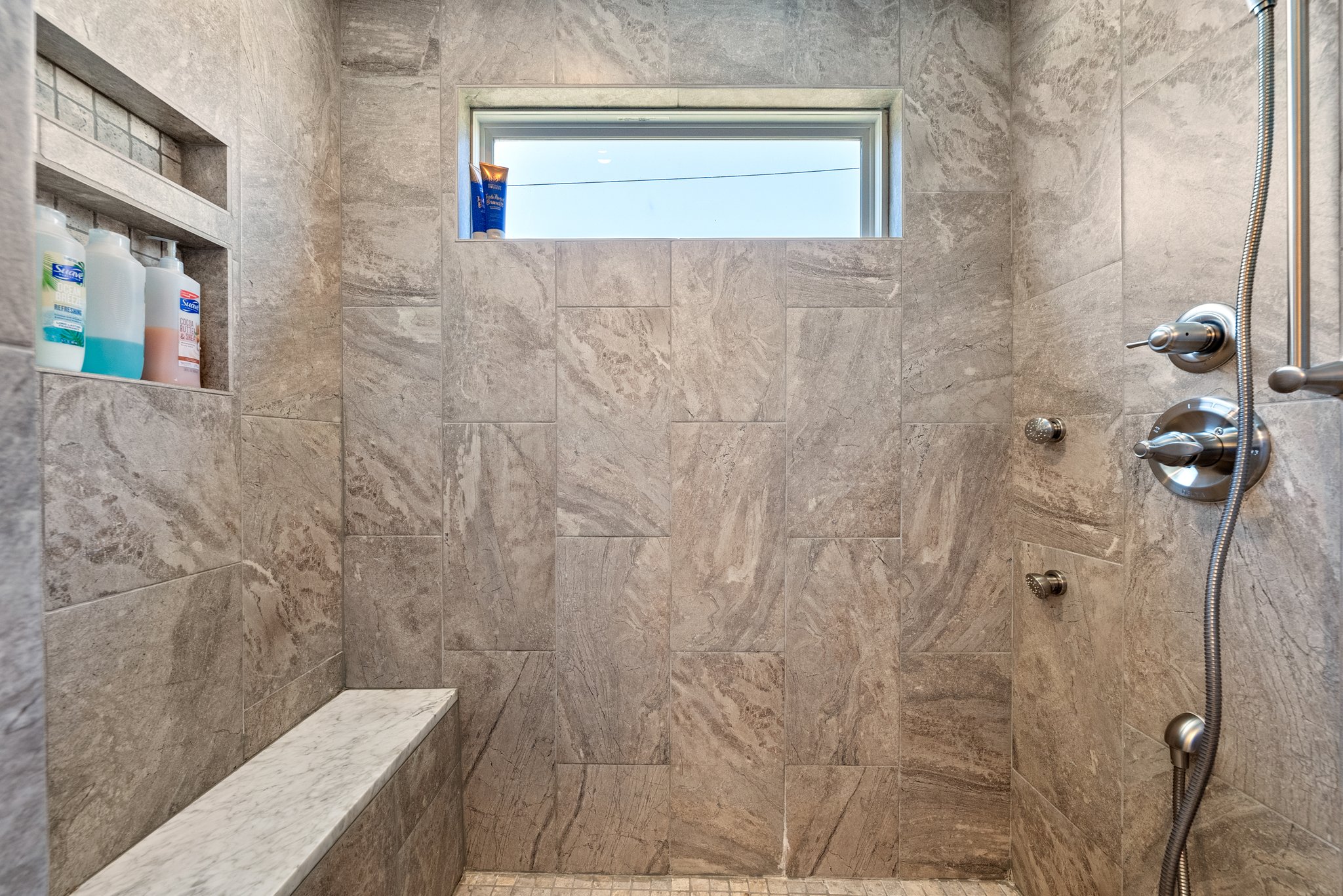 Close-up view of master bathroom shower with built-in shelf