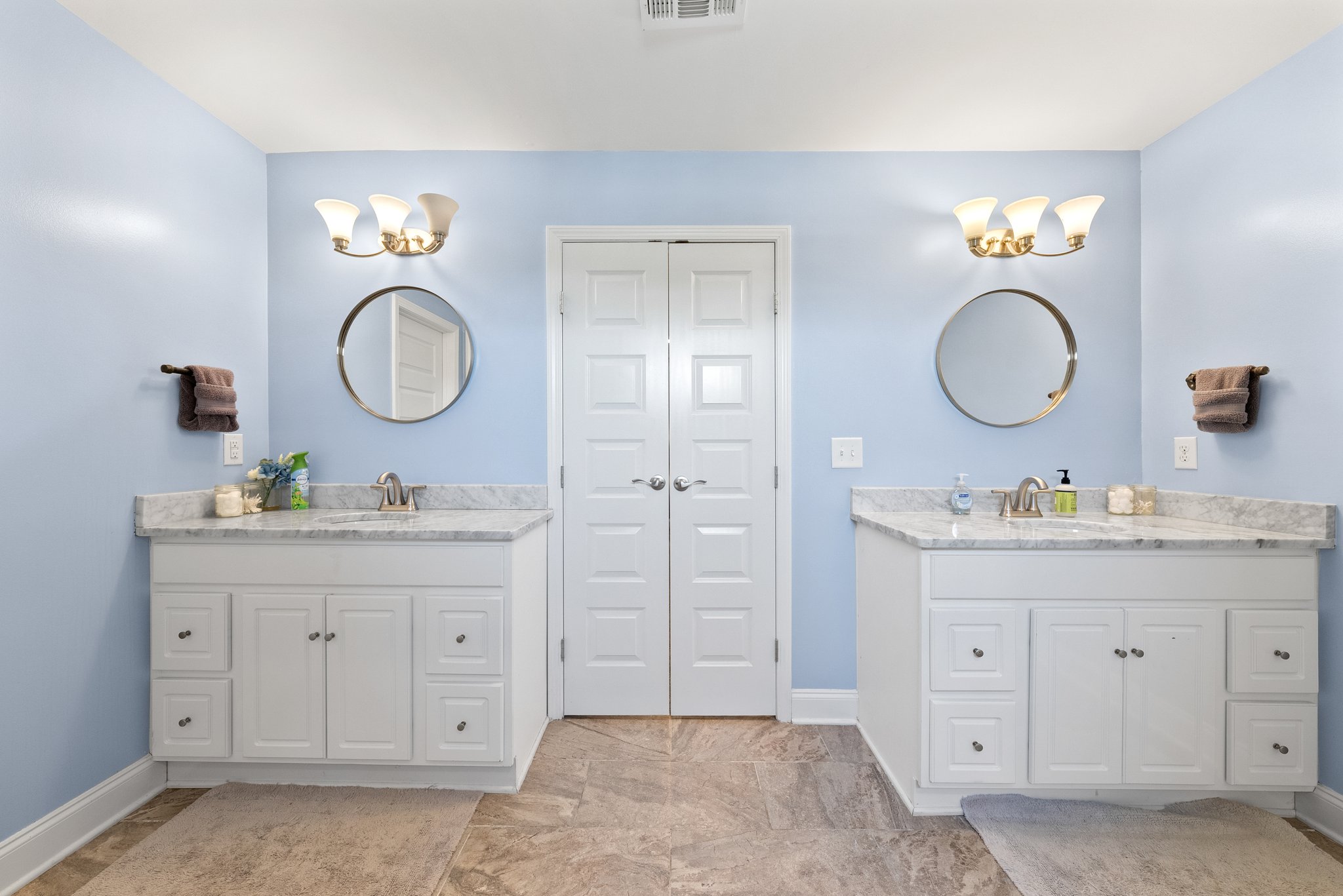 Double vanity in master bathroom with large mirrors and soft lighting