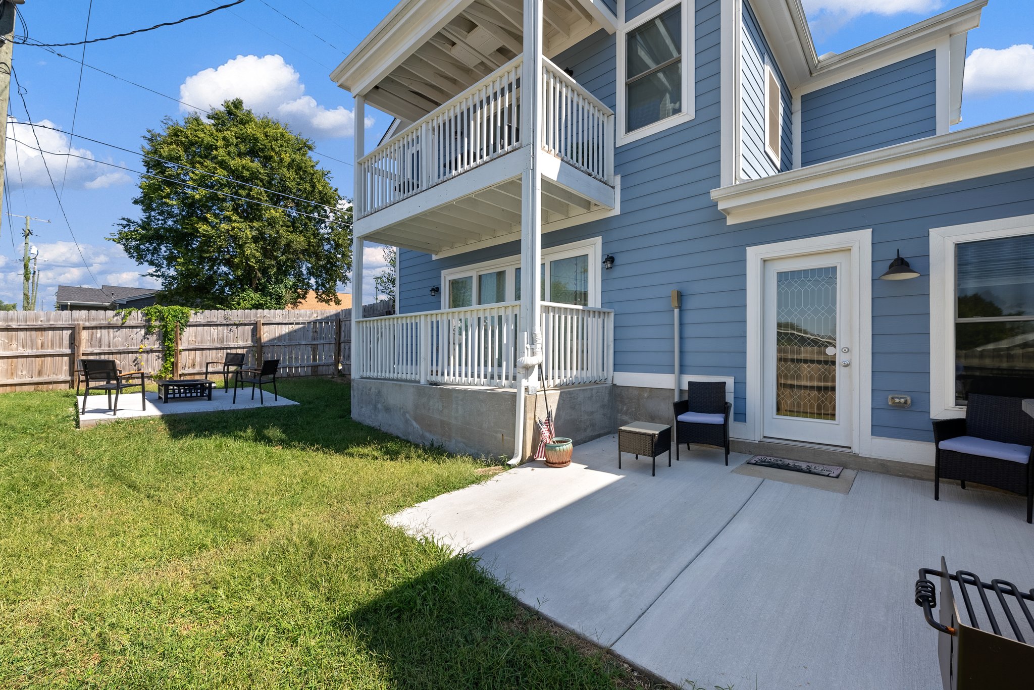 Backyard view showing two-story deck and fenced yard