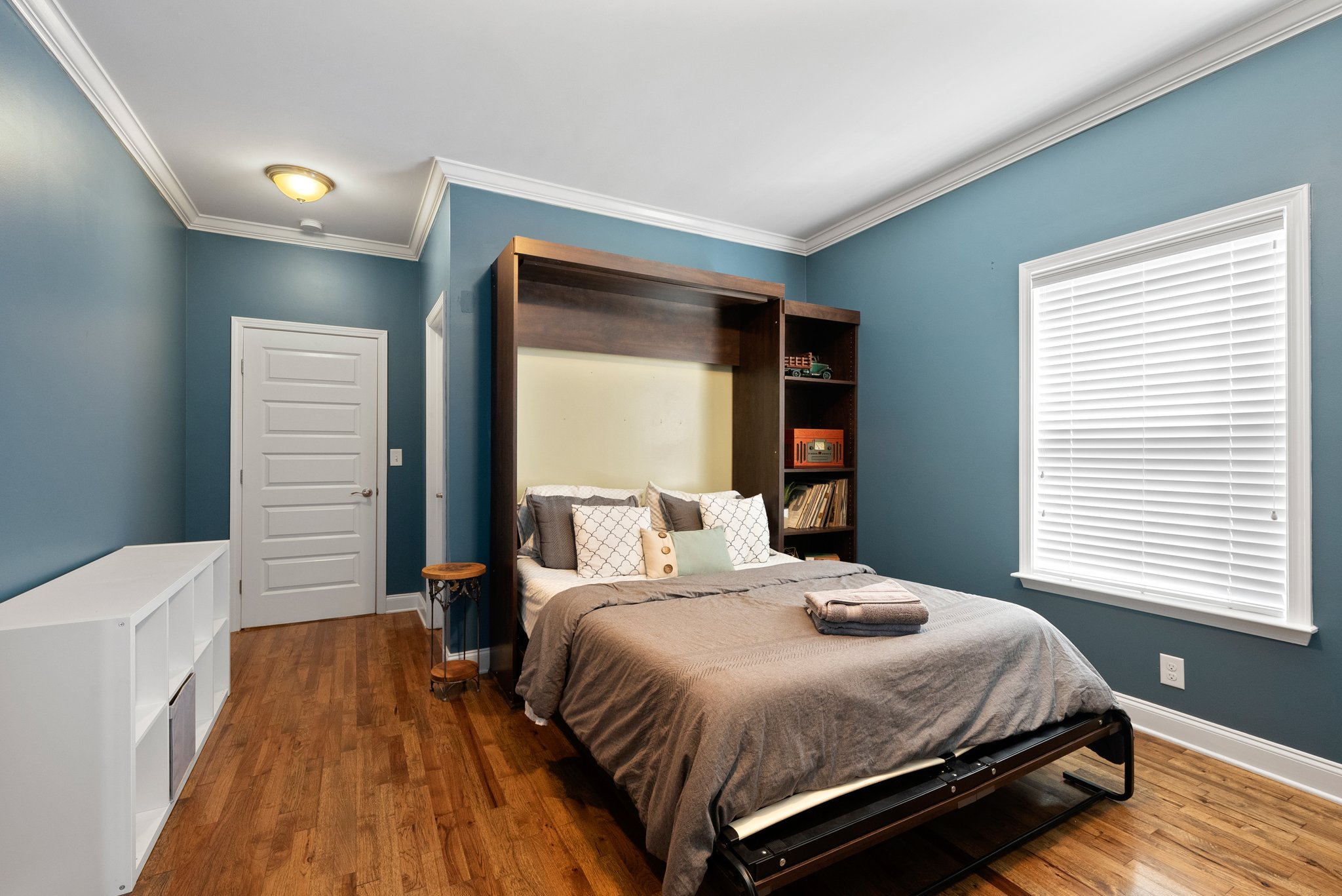 Murphy bed room with built-in shelves and stylish d?cor