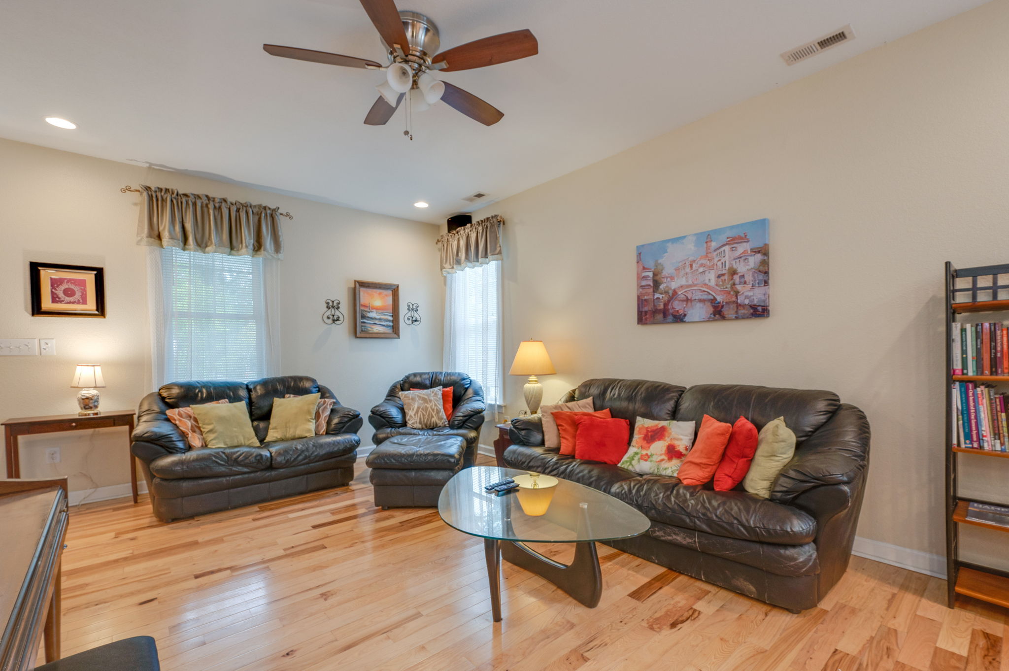 Another angle of the cozy living room with black leather seating and warm lighting.