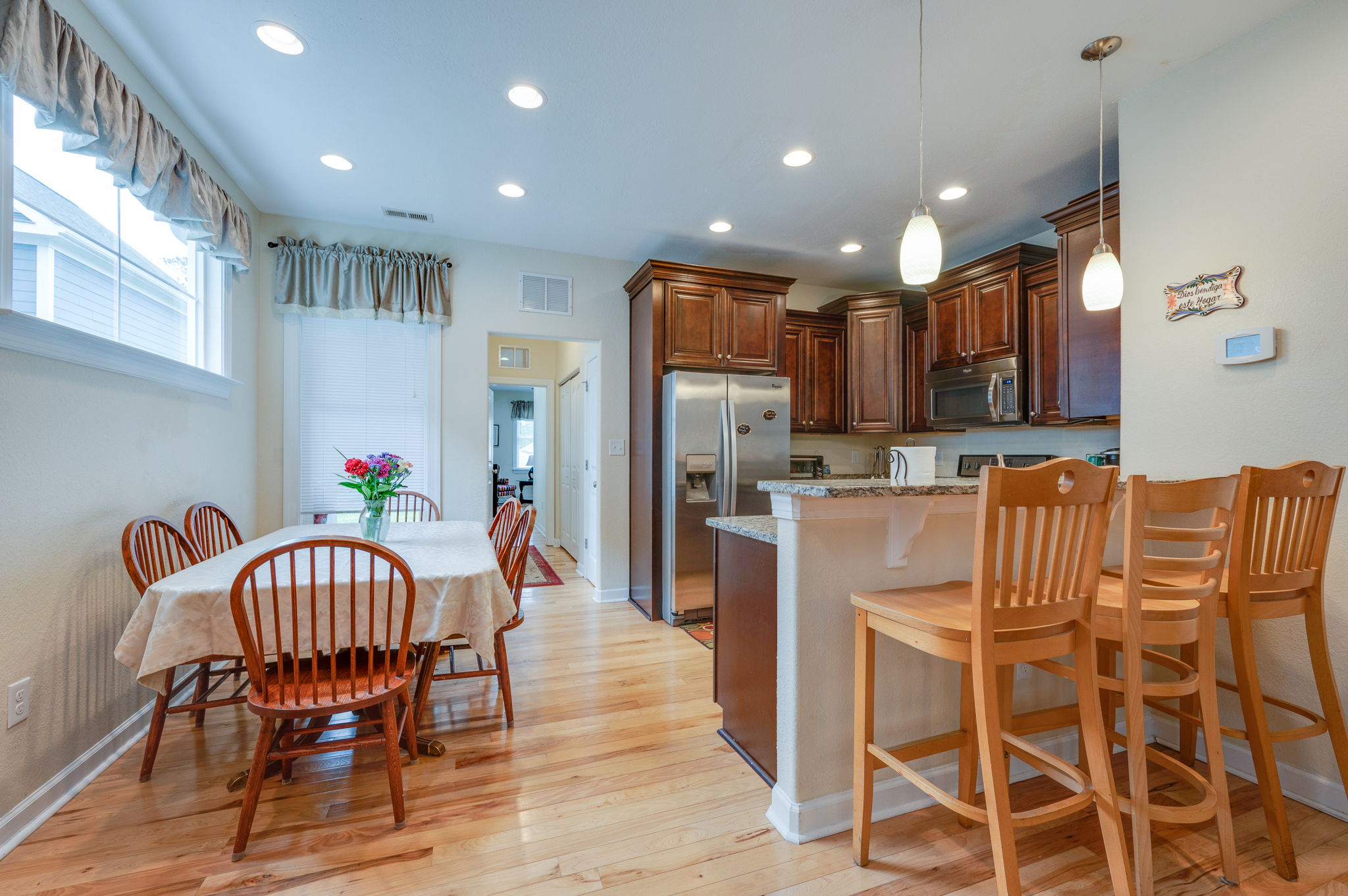 Dining area with a wooden table, chairs, and a decorative bookshelf in the background.