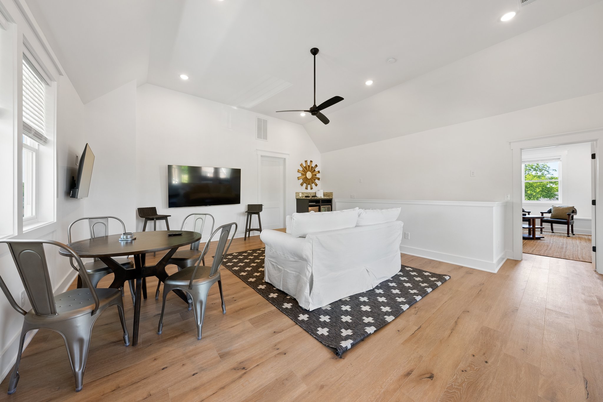 Bright Loft Living Room with White Couch, TV, and Dining Table