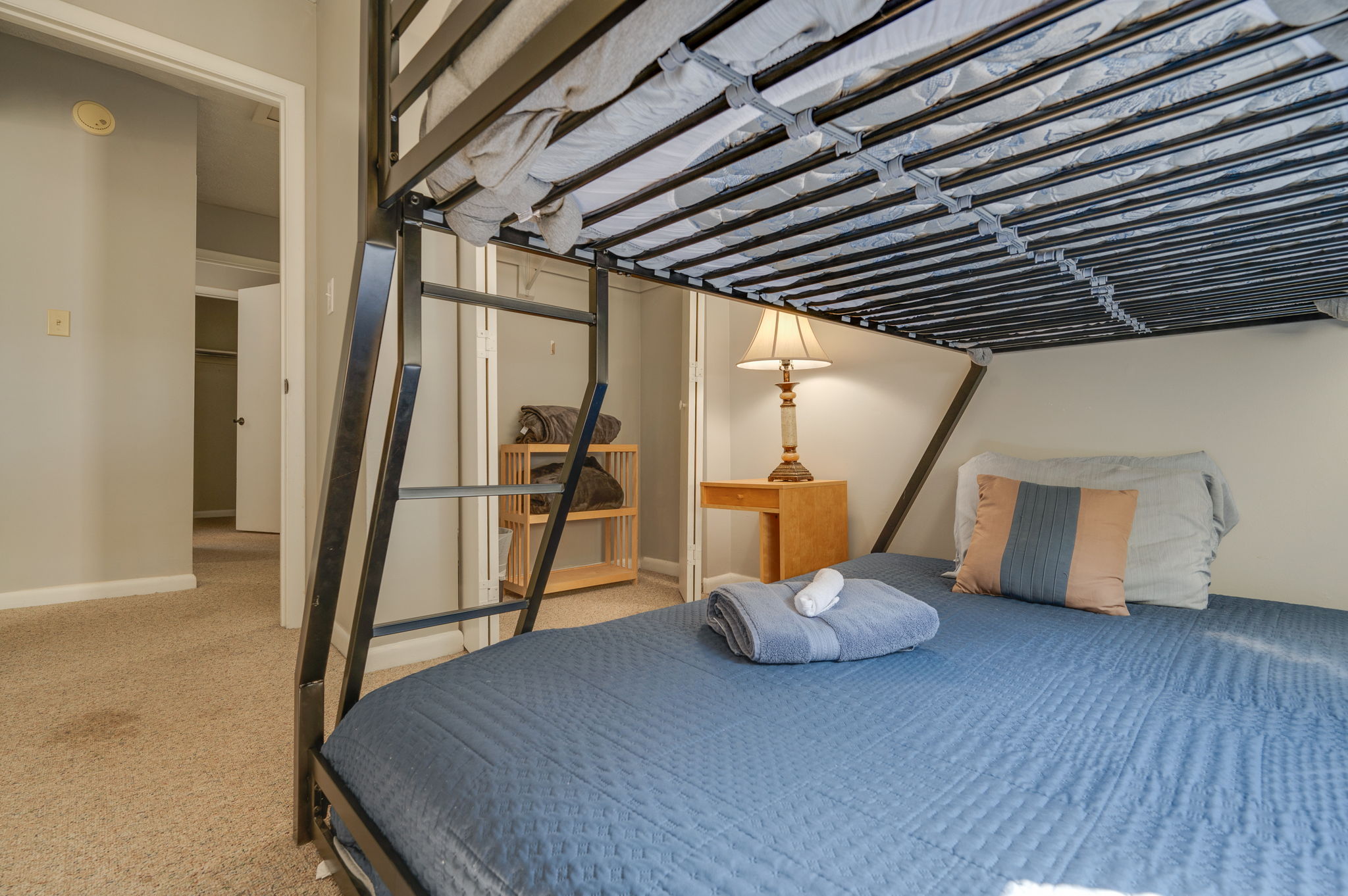 Lower view of bunk bed setup with soft lighting and bedside table