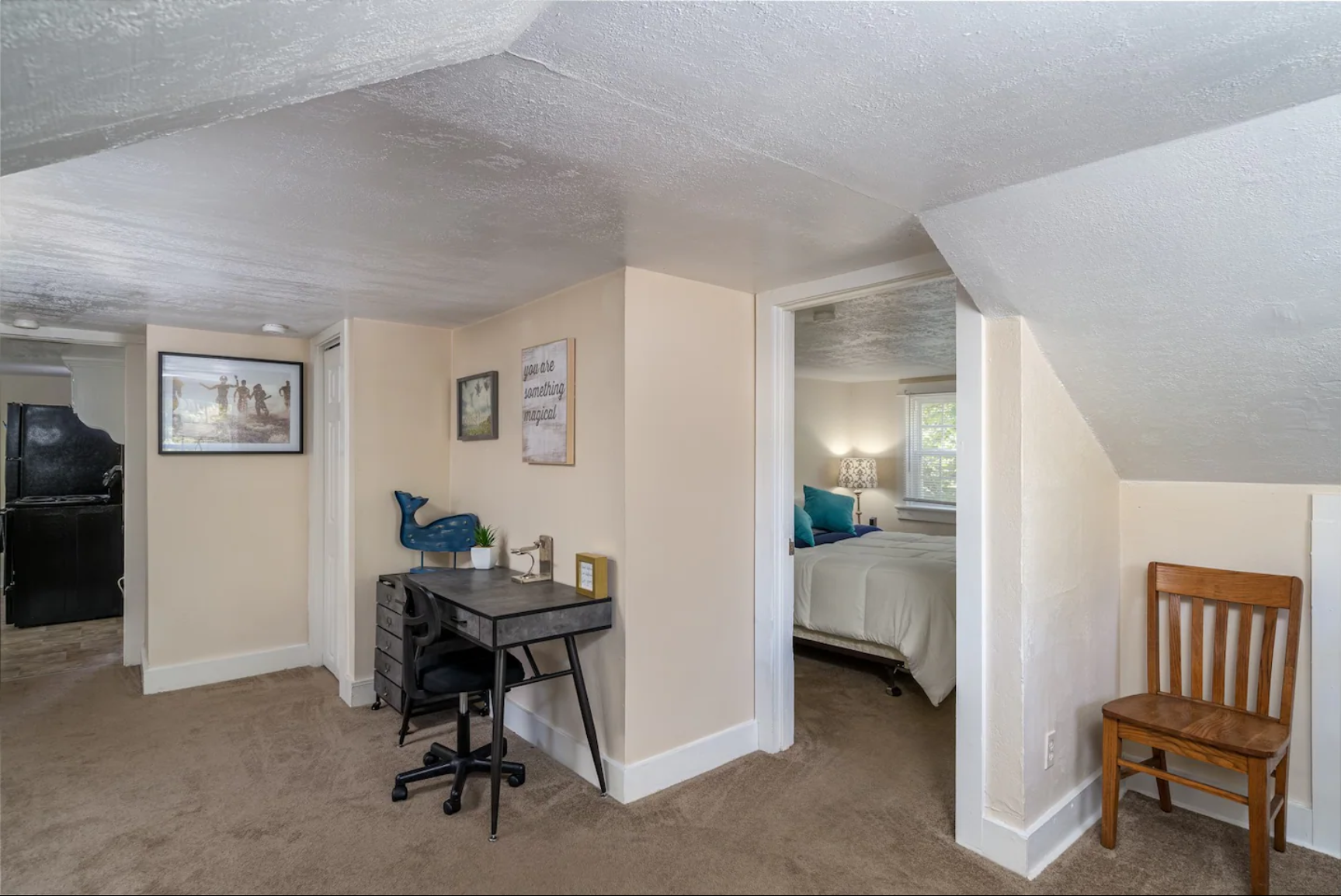 Entryway with a small desk, decorative wall art, and bedroom access.