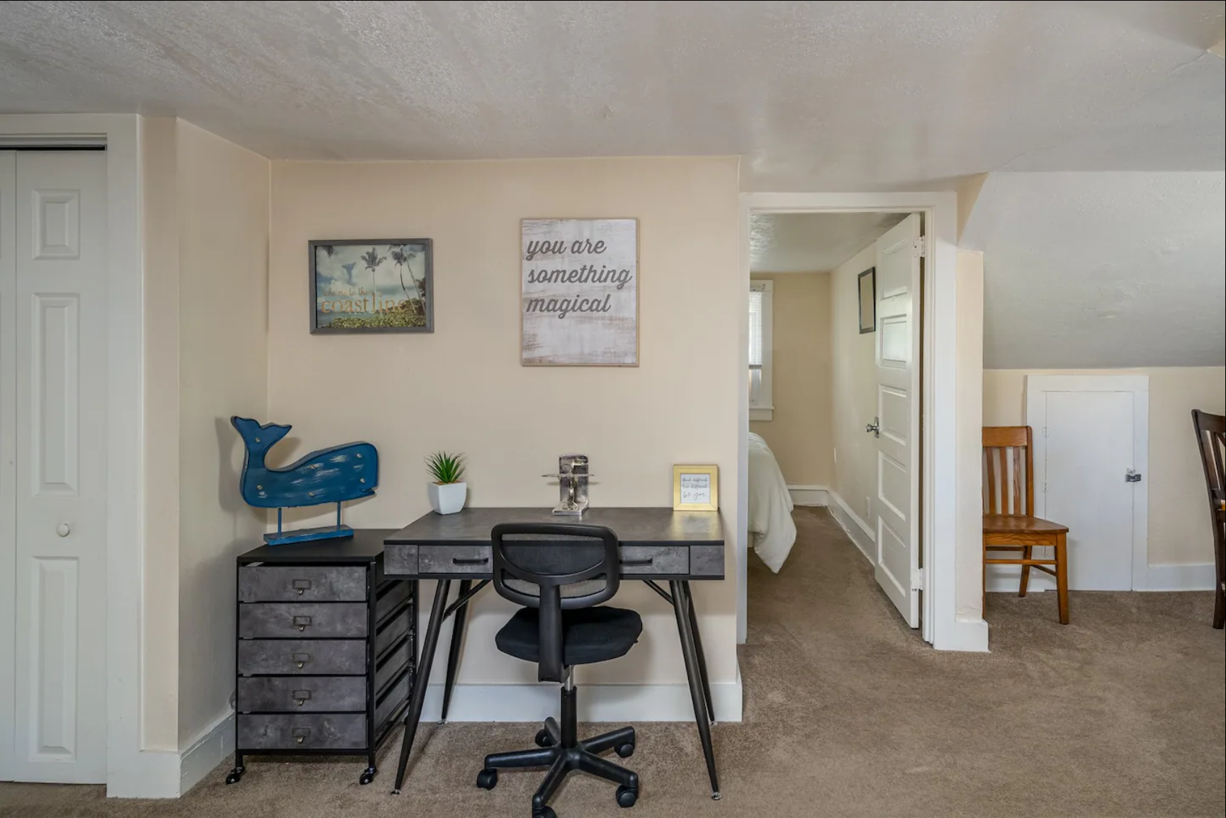 Compact home office setup with a desk, chair, and wall decor.