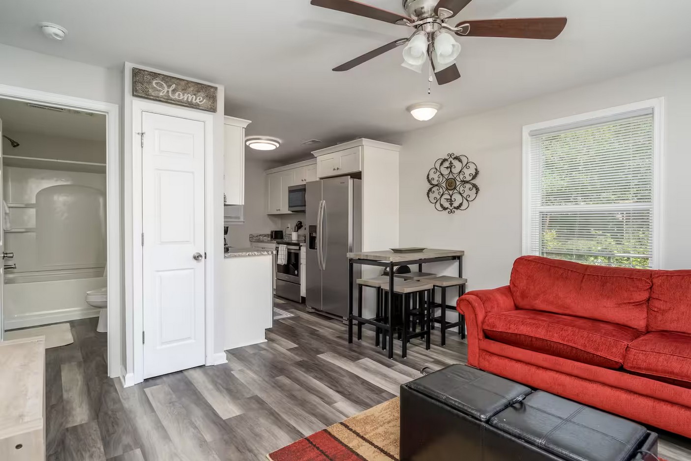 Inviting living space with a ceiling fan, decorative wall art, and a cozy seating arrangement.