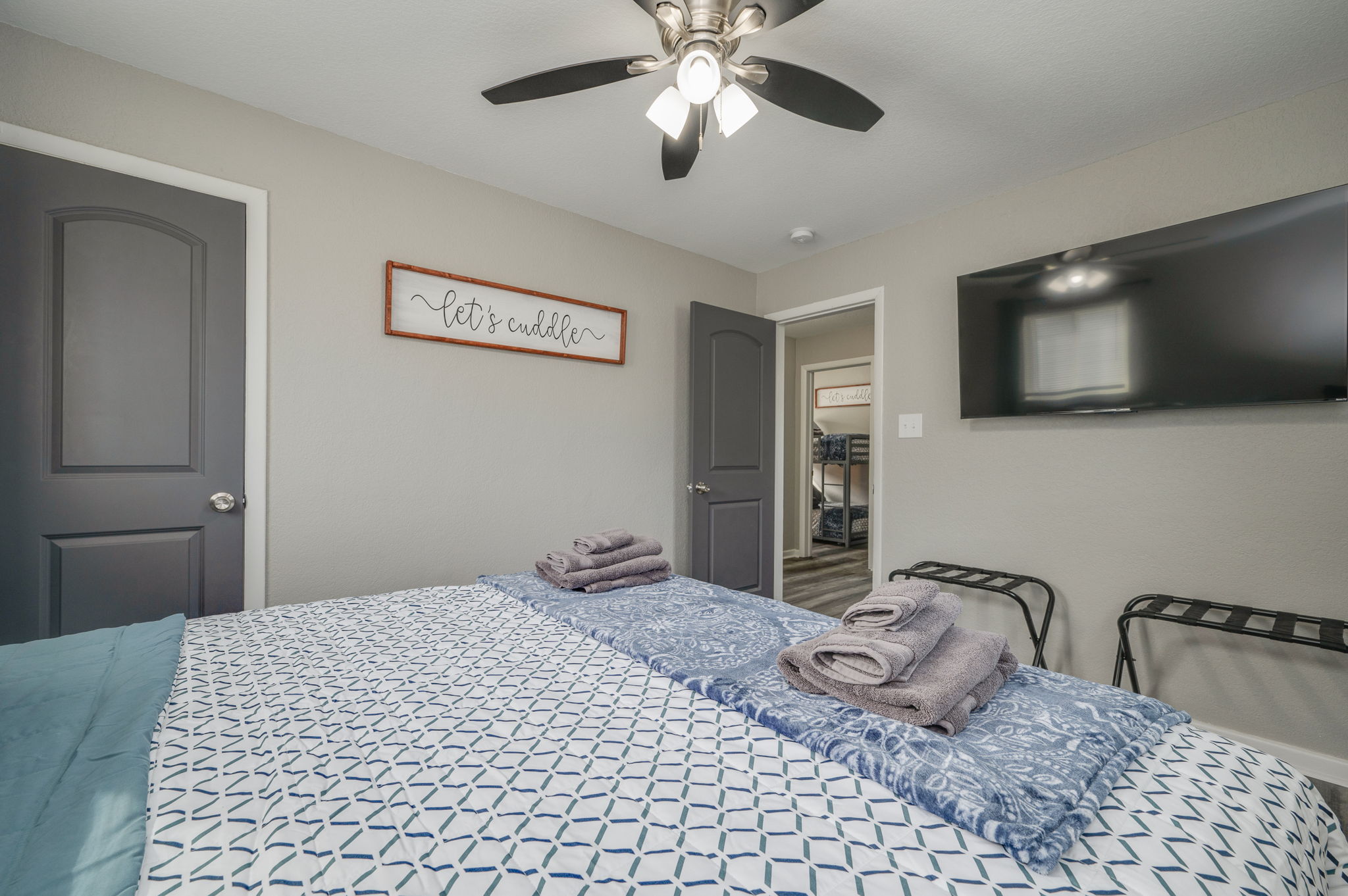 Cozy bedroom with a king bed, wall-mounted TV, and soft lighting
