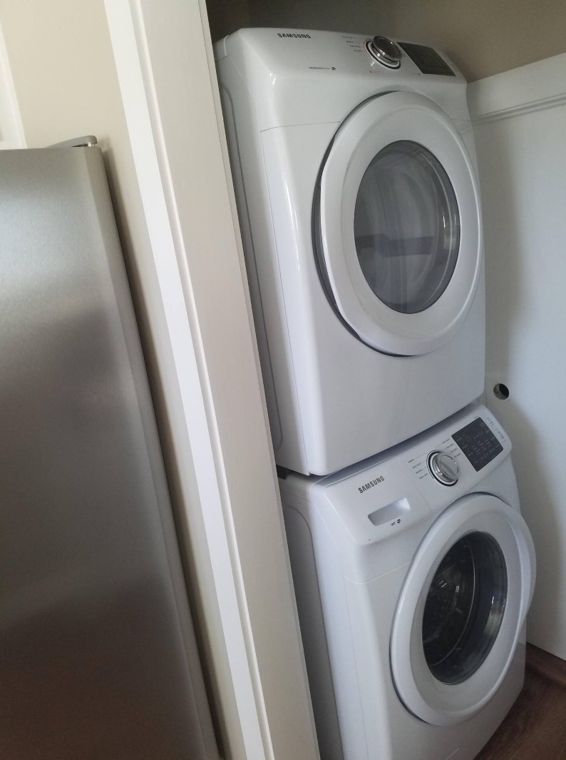 Compact laundry area with stacked Samsung washer and dryer