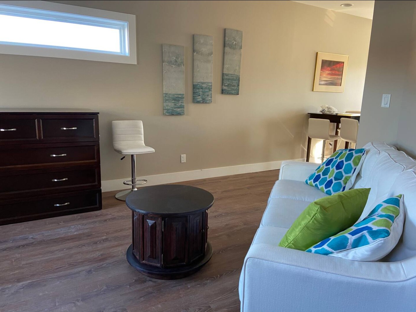 Living area with white couch, colorful pillows, and modern decor